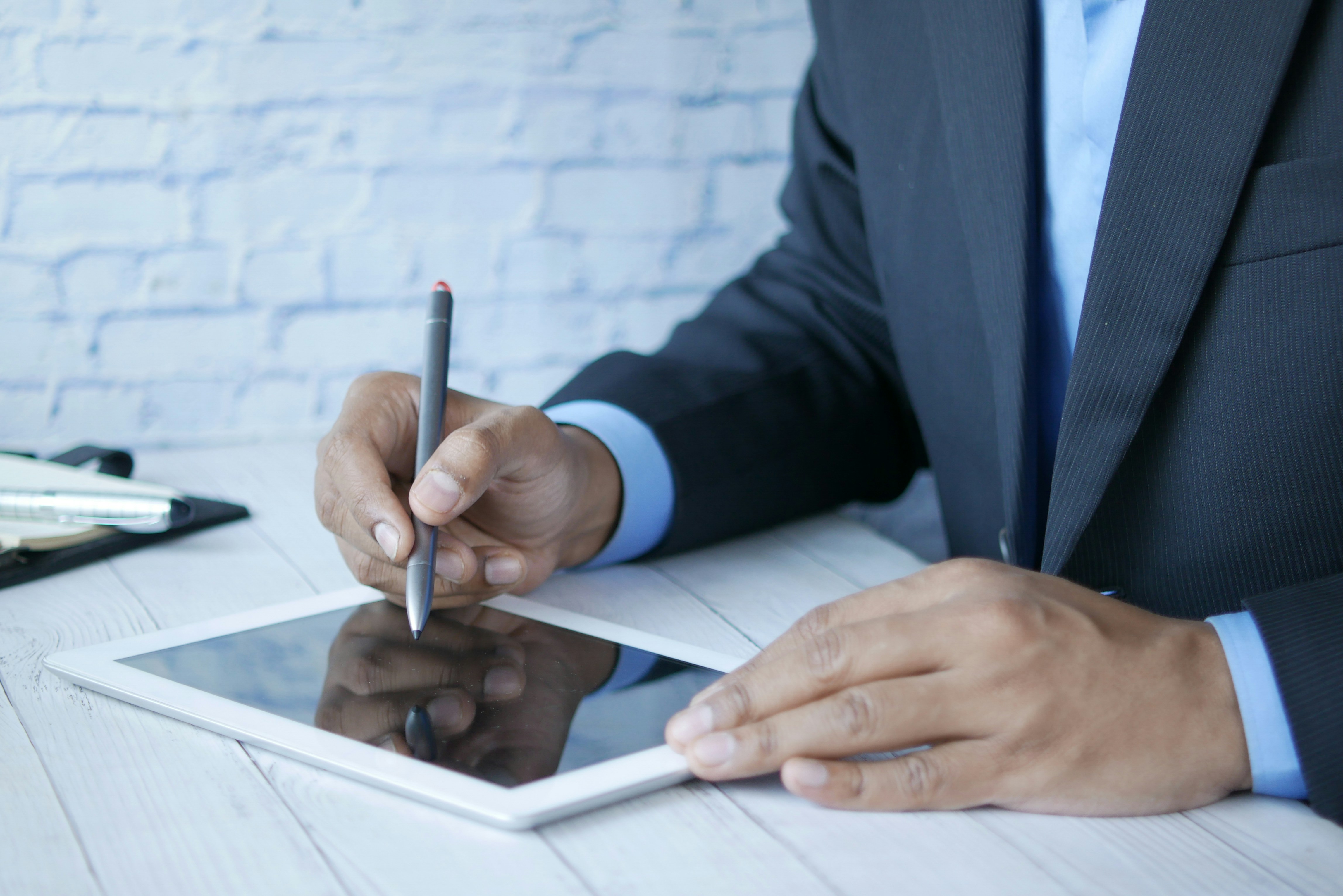 a man in a suit writing on a tablet by Towfiqu barbhuiya